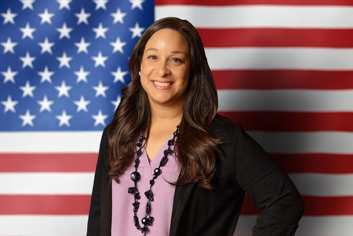 Portrait of Alani Bankhead in front of the United States flag.