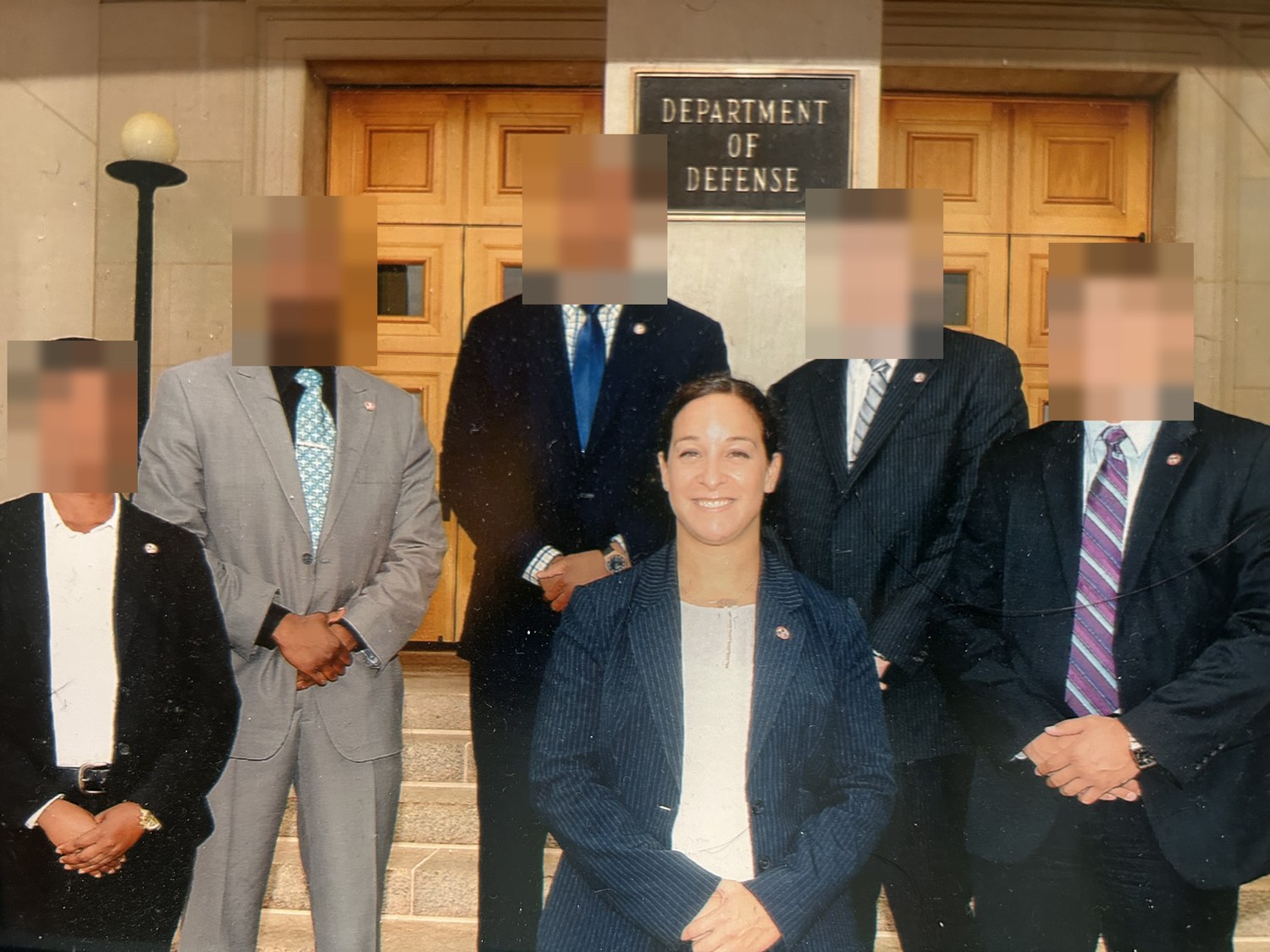 Alani Bankhead with her security detail in civilian suits, on the steps of a Department of Defense entrance.