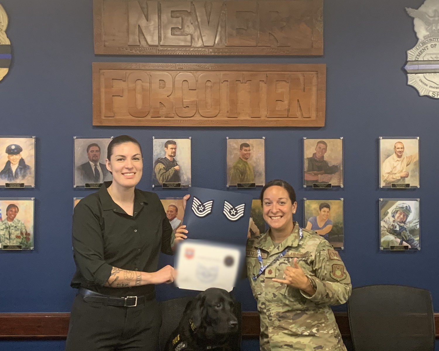 Alani Bankhead in uniform presenting a promotion certificate at an Office of Special Investigations ceremony, a working K9 seated between her and the recipient.