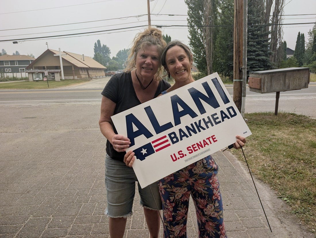 Two supporters holding an Alani Bankhead yard sign